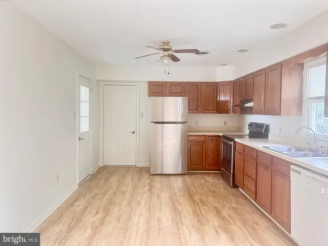a kitchen with a refrigerator a sink and cabinets