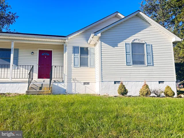 a view of a house with backyard and a garden