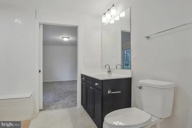 a bathroom with a granite countertop sink a toilet and shower