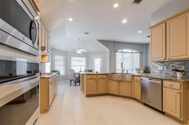 a large kitchen with stainless steel appliances lots of counter top space