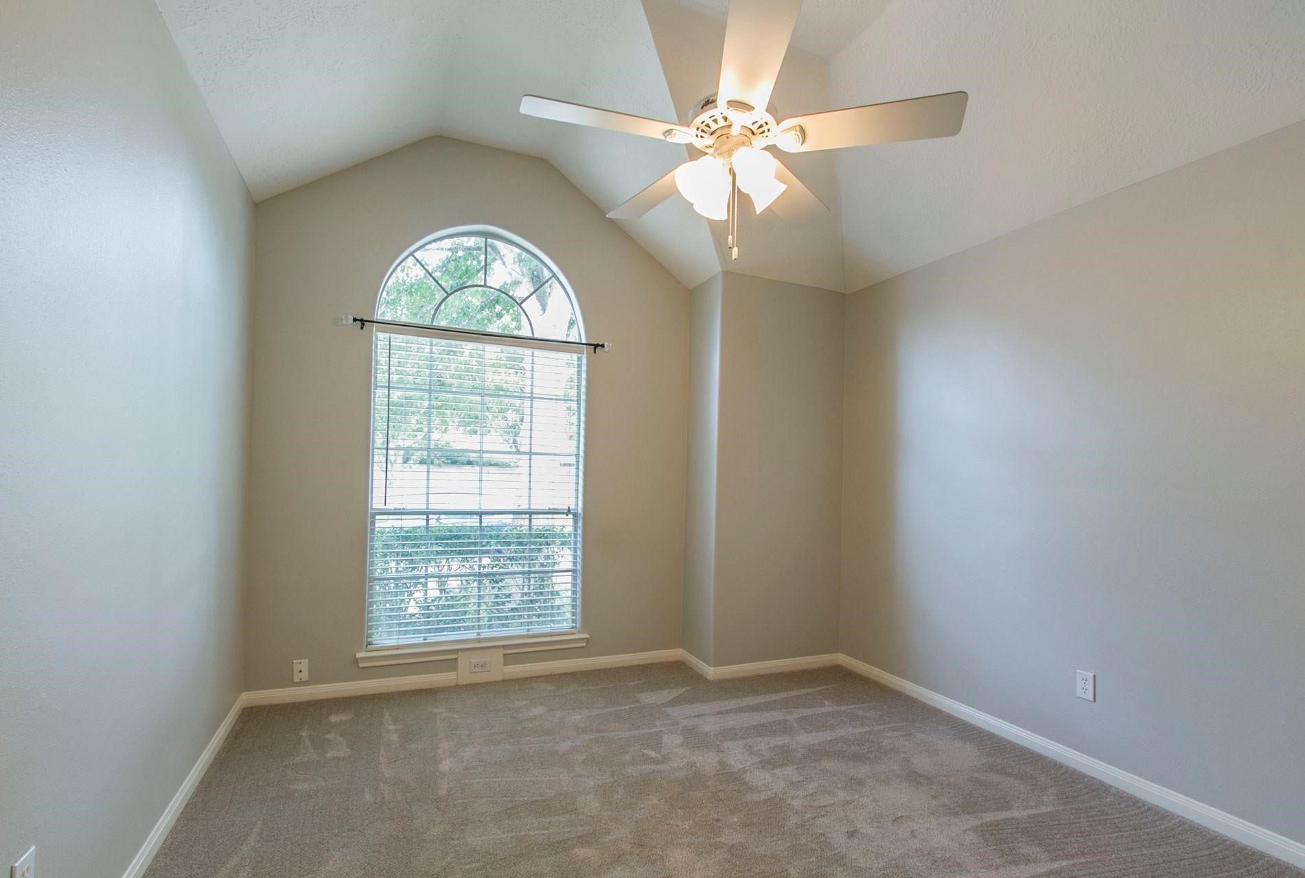 1230 Sienna Hill Drive Houston, TX 77077 - Photo 21 of 42 an empty room with windows and chandelier fan