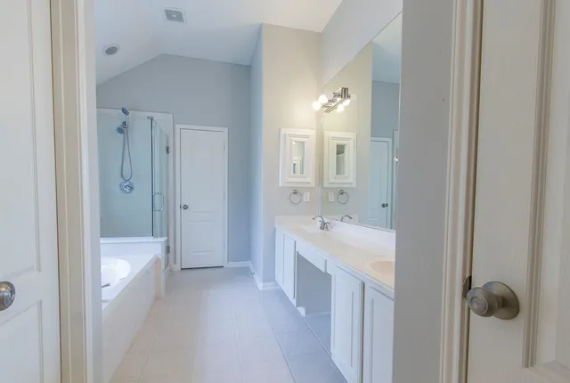 a bathroom with a tub sink and mirror
