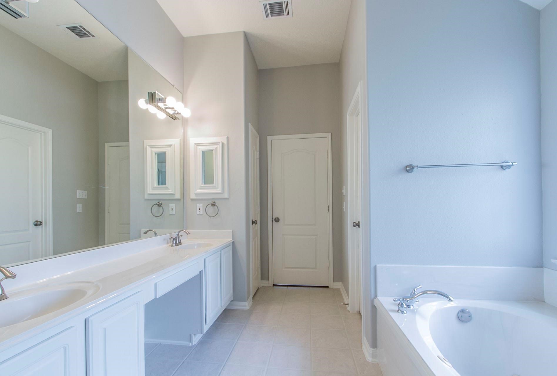 1230 Sienna Hill Drive Houston, TX 77077 - Photo 31 of 42 a spacious bathroom with a bathtub sink and mirror