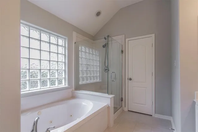 a bathroom with a tub a sink and a window
