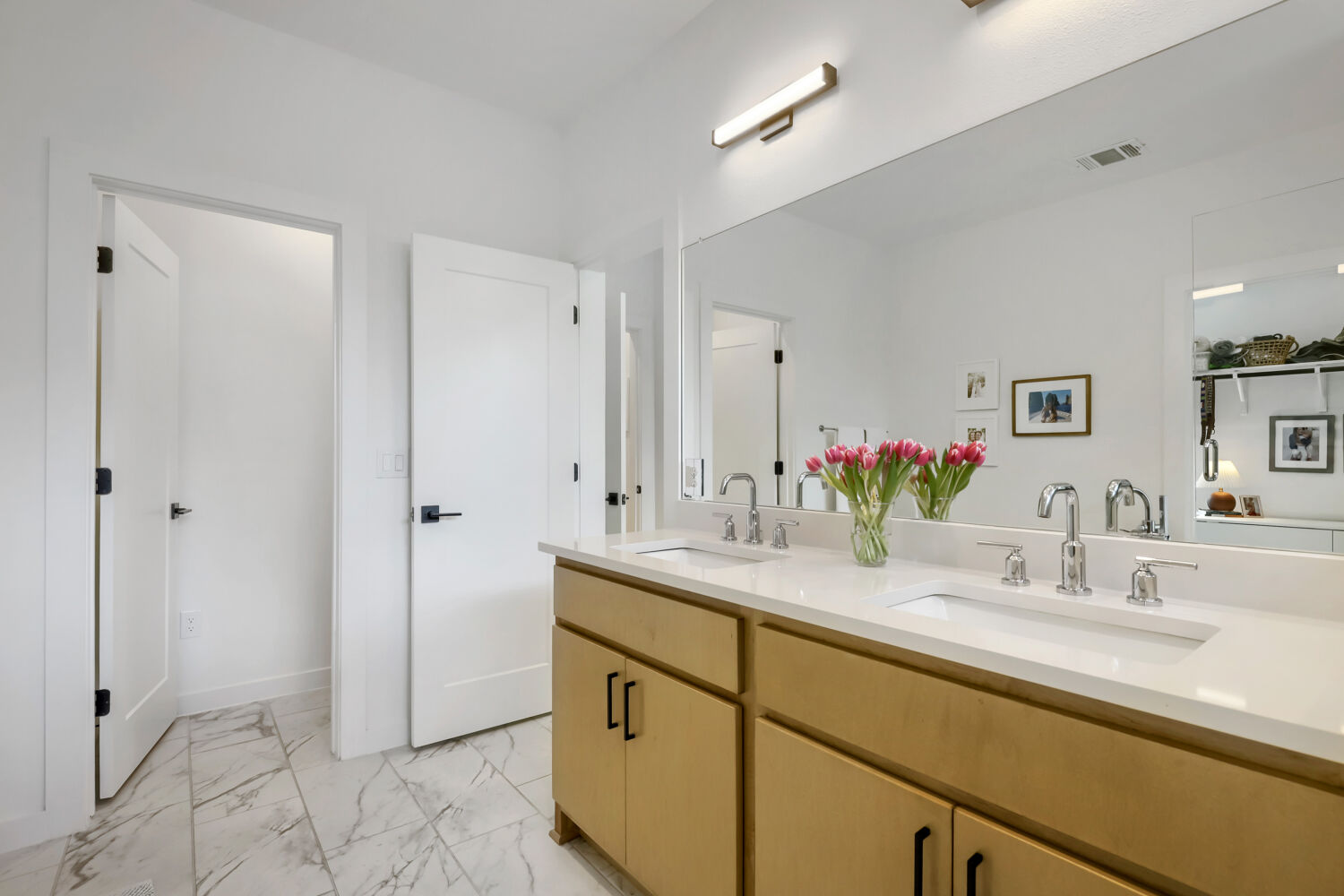 4804 Ribbecke Avenue, Unit A Austin, TX 78721 - Photo 12 of 32 The bathroom features a double vanity with light wood cabinetry, white countertops, and dual undermount sinks with chrome faucets