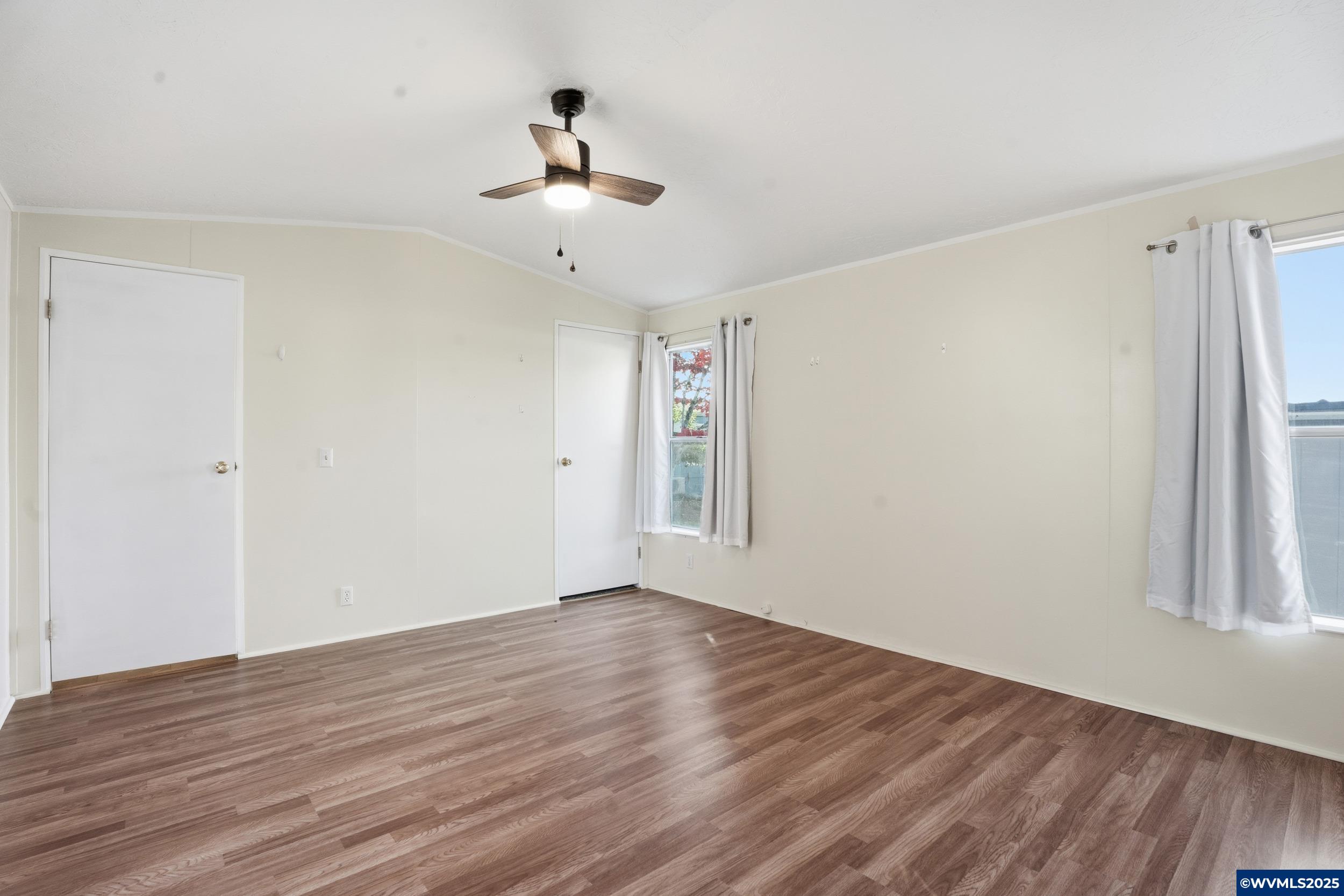 277 Edwards Road, Unit 145 Monmouth, OR 97361 - Photo 17 of 47 a view of empty room with wooden floor and fan