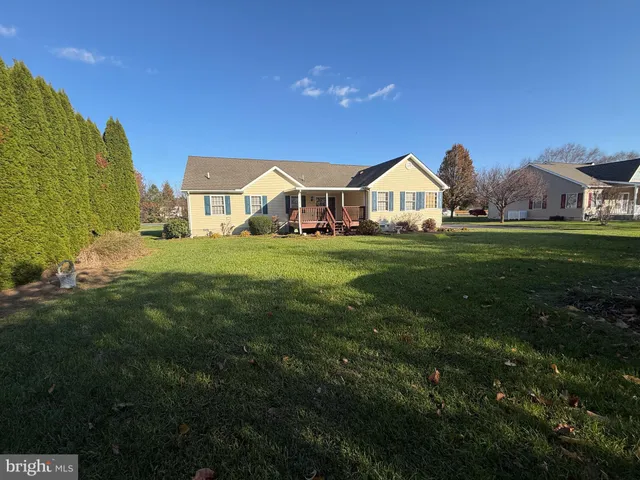 a view of a big house with a big yard and large trees