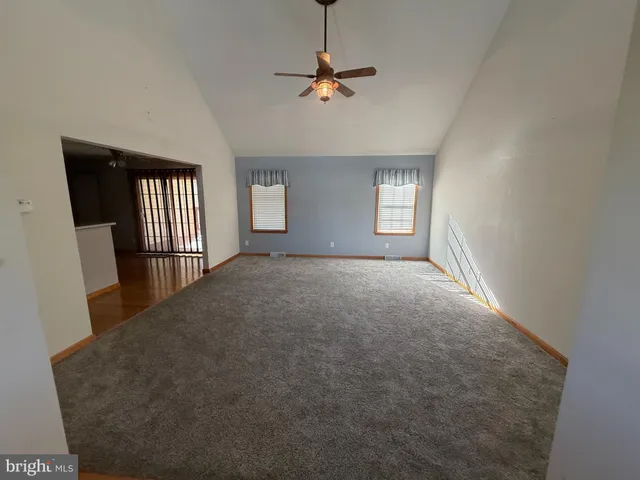 a view of a livingroom with a ceiling fan and window