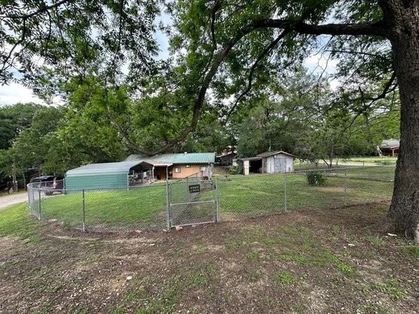 a view of a house with backyard and trees