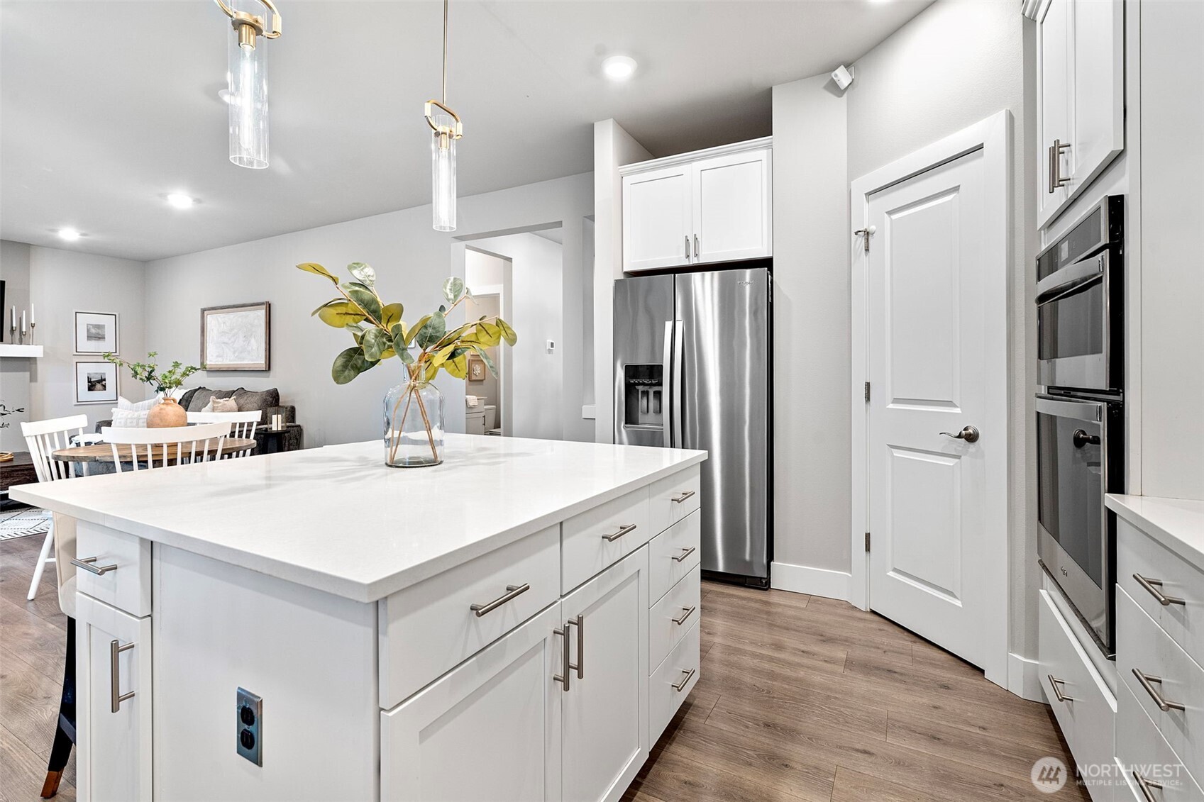 4526 Olympus Loop Gig Harbor, WA 98332 - Photo 11 of 38 a kitchen with stainless steel appliances a white refrigerator a sink dishwasher and white cabinets with wooden floor