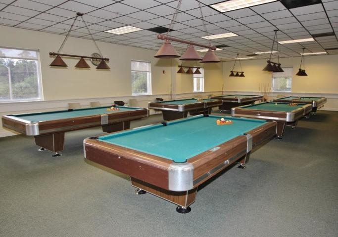 a room with pool table and windows