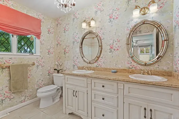 a bathroom with a granite countertop toilet a sink and a mirror