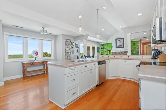 a kitchen that has a lot of cabinets in it and wooden floor