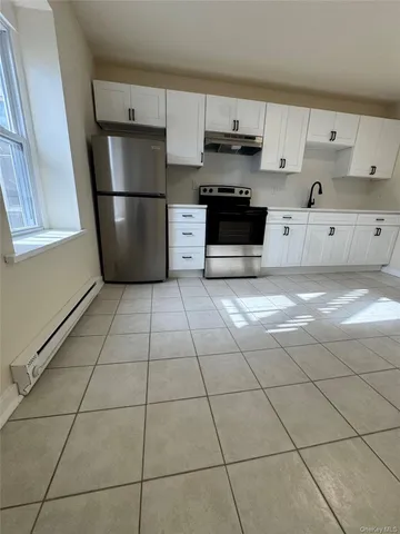 a kitchen with granite countertop a refrigerator and a stove top oven