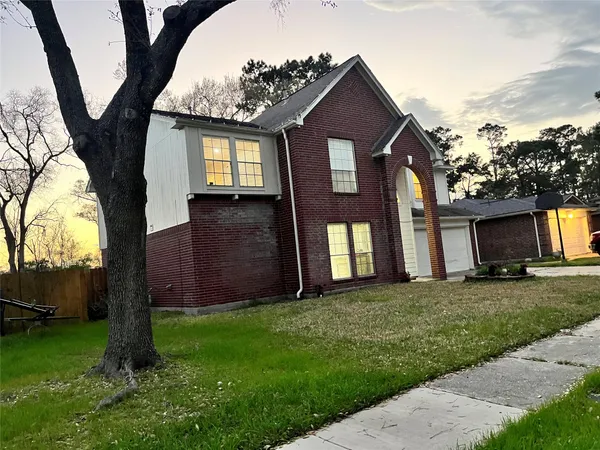a front view of a house with a yard and trees