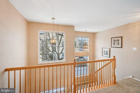 a view of a livingroom with a chandelier fan and a window