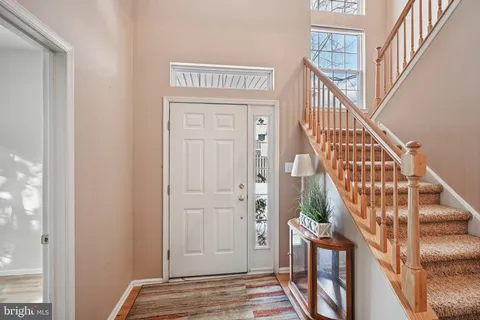 a view of front door with wooden floor and stairs
