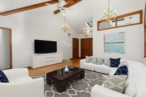 a living room with furniture a window and a wooden floor