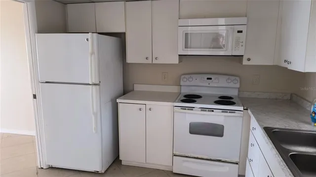 a white refrigerator freezer sitting inside of a kitchen
