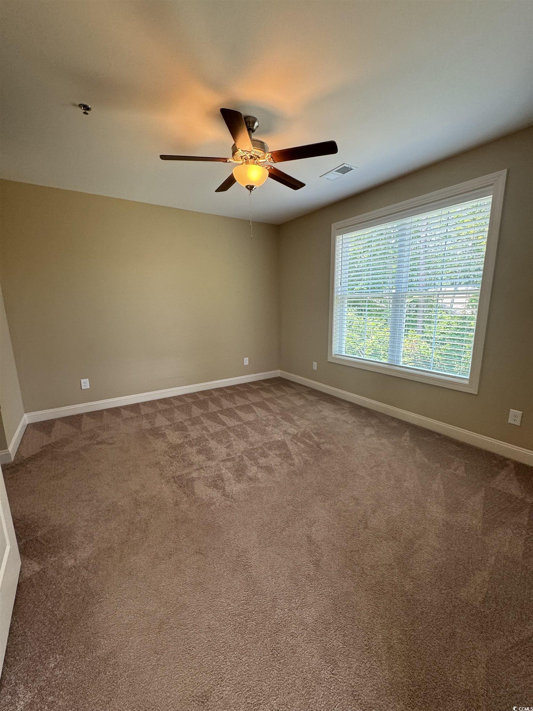 144 Puffin Drive, Unit 2E Pawleys Island, SC 29585 - Photo 12 of 17 Unfurnished room with light carpet and ceiling fan