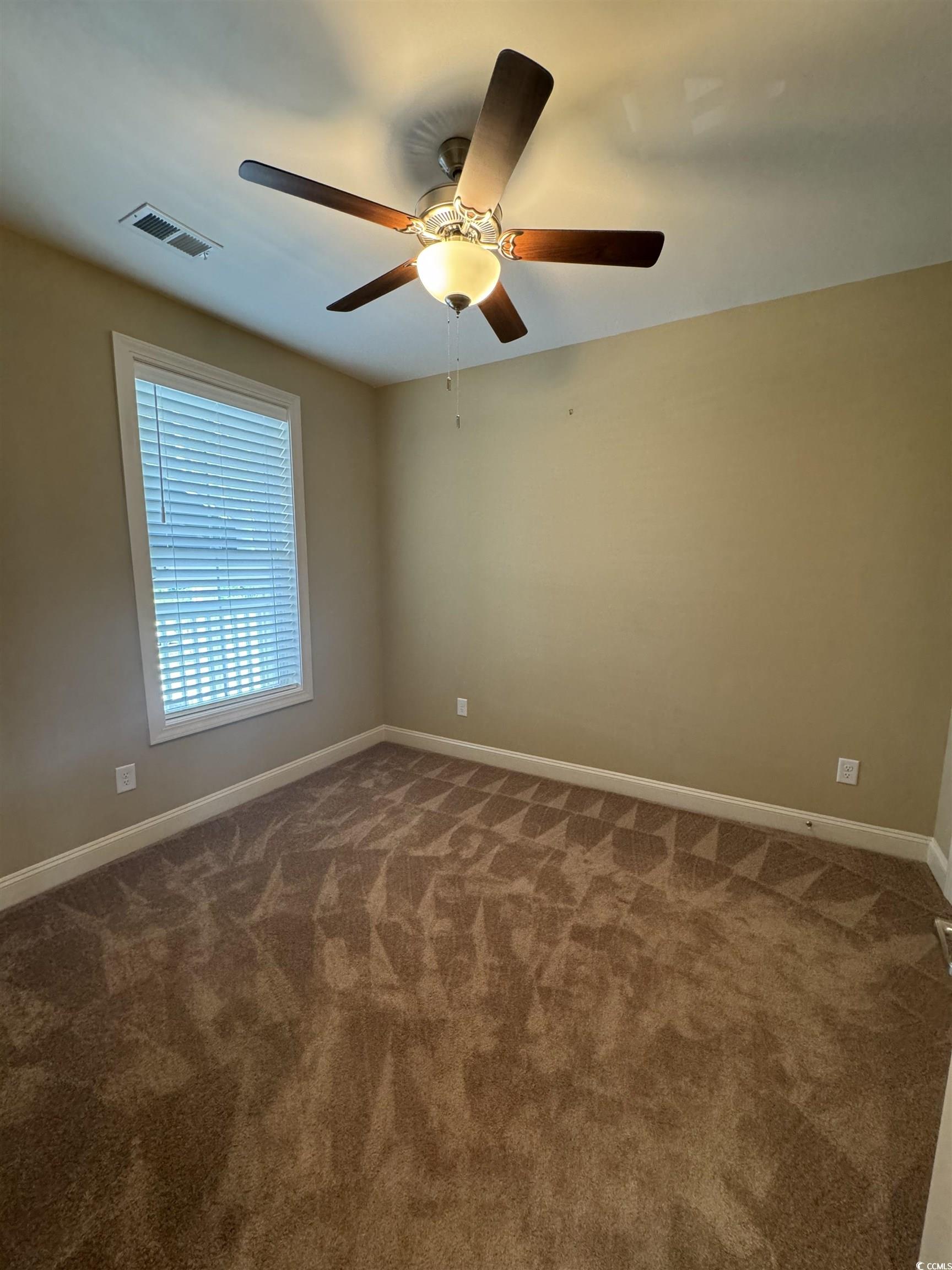 144 Puffin Drive, Unit 2E Pawleys Island, SC 29585 - Photo 6 of 17 Unfurnished room featuring dark carpet and ceiling fan