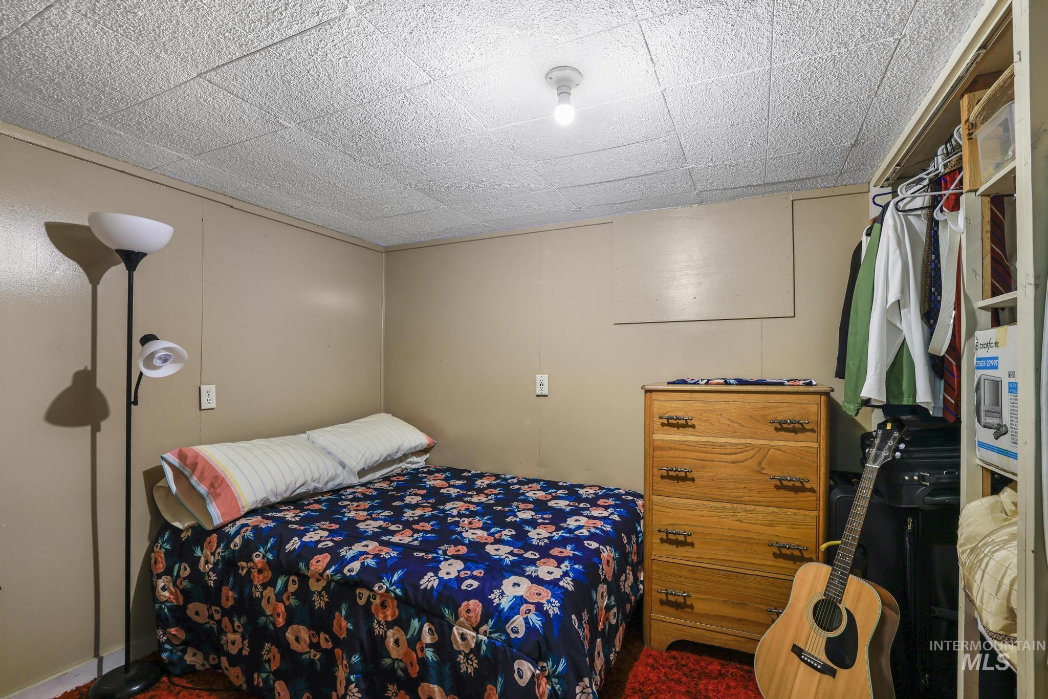 19591 Queen Crown Road Carey, ID 83320 - Photo 19 of 37 Bedroom featuring paneling walls and a textured ceiling