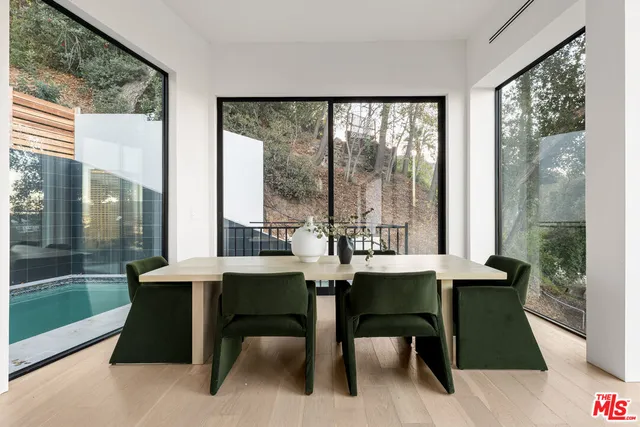 a dining room with furniture and a floor to ceiling window