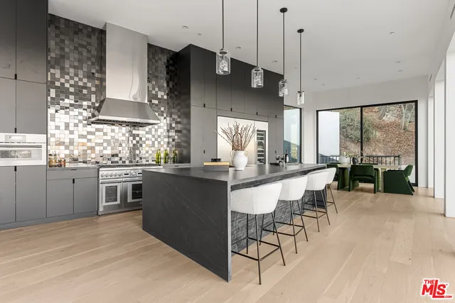 a kitchen with stainless steel appliances kitchen island granite countertop a stove a sink and a refrigerator