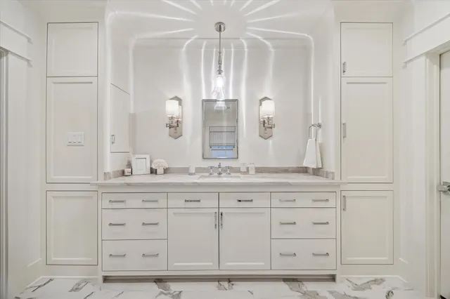 a bathroom with white cabinets and a sink