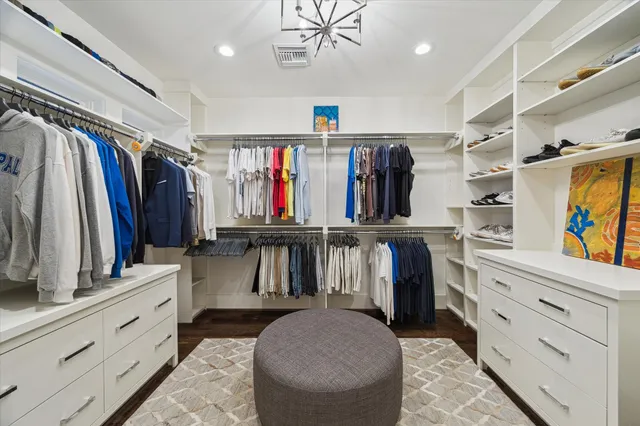 a view of walk in closet with clothes and shoes