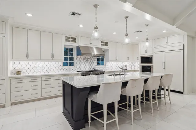 a kitchen with kitchen island granite countertop a sink counter and chairs