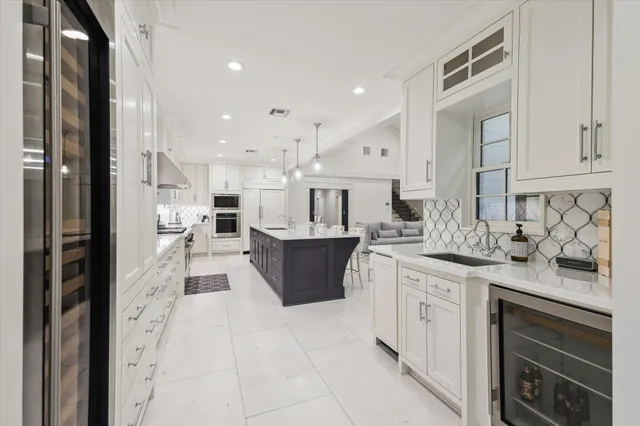 a large kitchen with stainless steel appliances kitchen island granite countertop a large counter top and view of living room