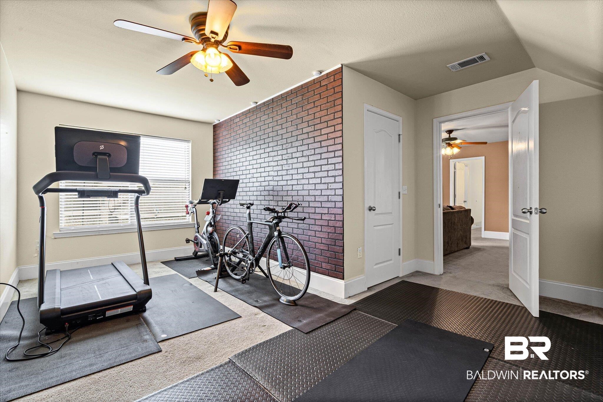 585 Sheffield Avenue Foley, AL 36535 - Photo 44 of 45 Versatile bonus room featuring a decorative brick accent wall, a window with blinds, and a ceiling fan with integrated lighting