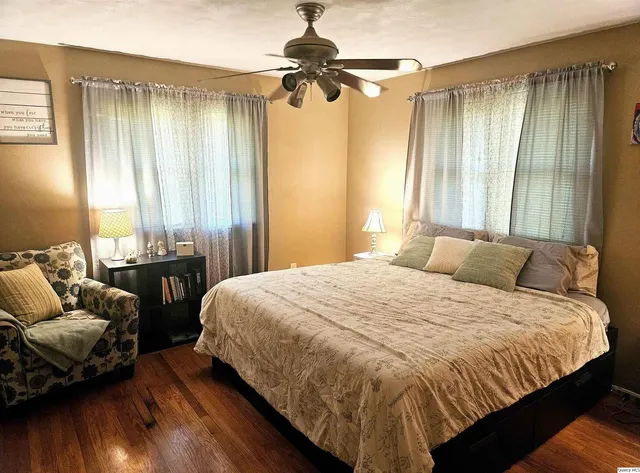 a bedroom with a bed and wooden floor