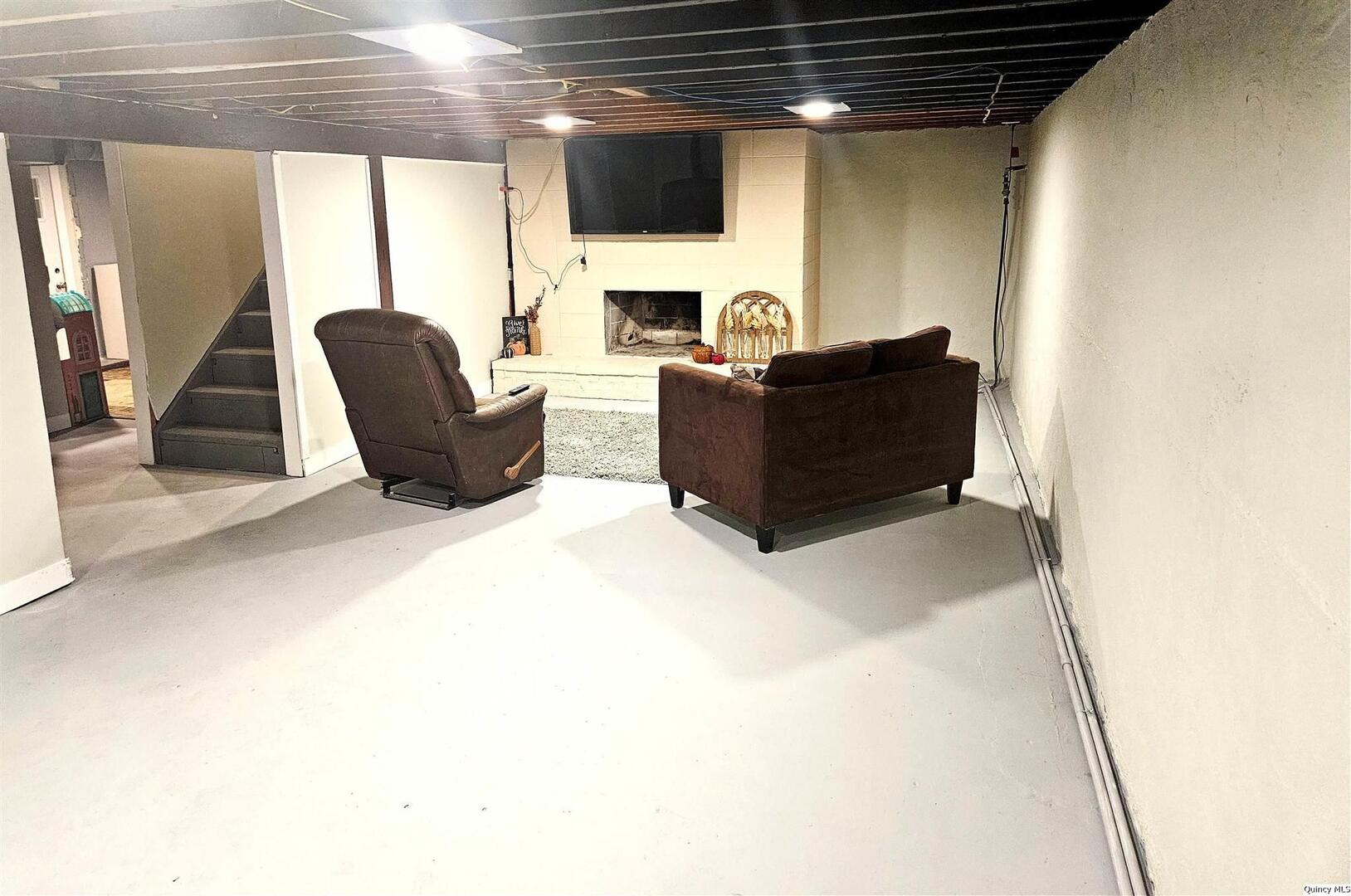 803 Maas Road Quincy, IL 62305 - Photo 6 of 28 a living room with furniture a flat screen tv and a fireplace