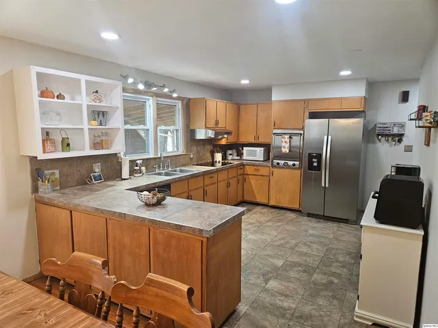 a kitchen with stainless steel appliances granite countertop a sink refrigerator and cabinets