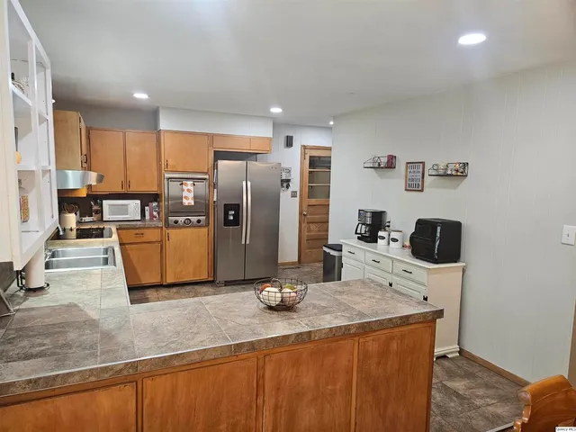 a kitchen with stainless steel appliances granite countertop a refrigerator a stove and a sink