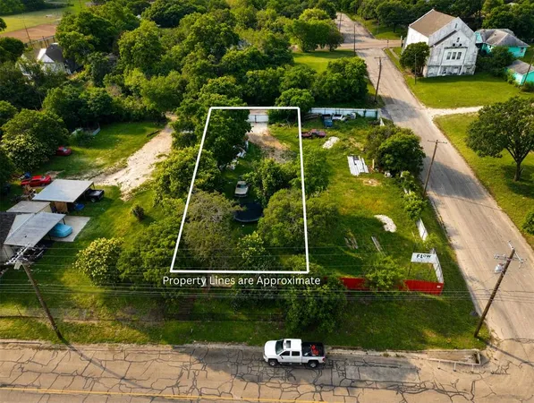 an aerial view of residential house with outdoor space and trees all around