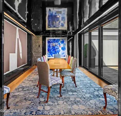 a dining room with furniture and a floor to ceiling window