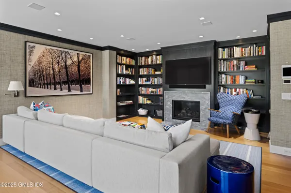 a living room with furniture a flat screen tv and a bookshelf