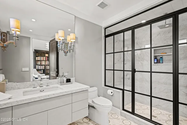 a bathroom with a double vanity sink toilet and a mirror