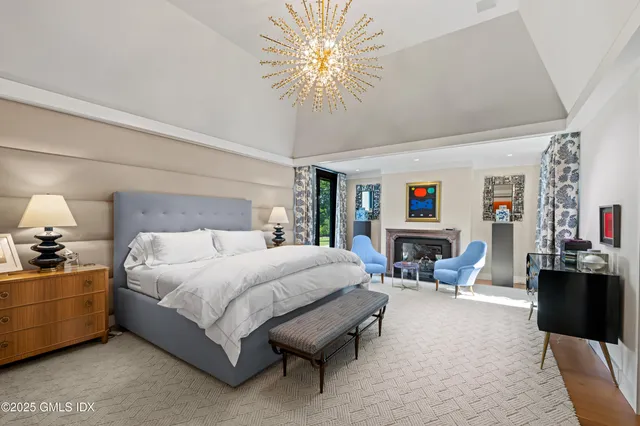 a spacious bedroom with a bed and fireplace