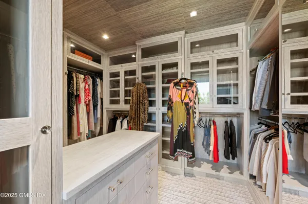 a view of walk in closet with clothes and shoes