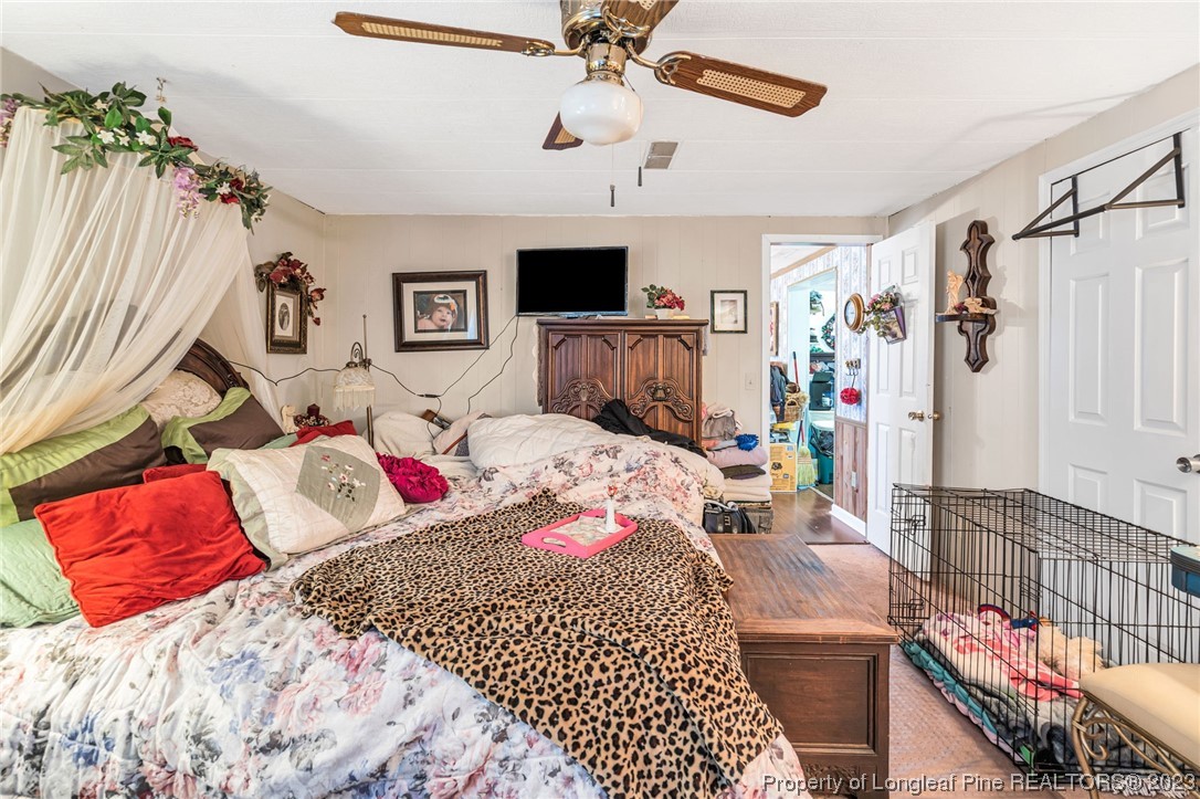 560 Moody Road Cameron, NC 28326 - Photo 12 of 29 a bedroom with a bed and a chandelier
