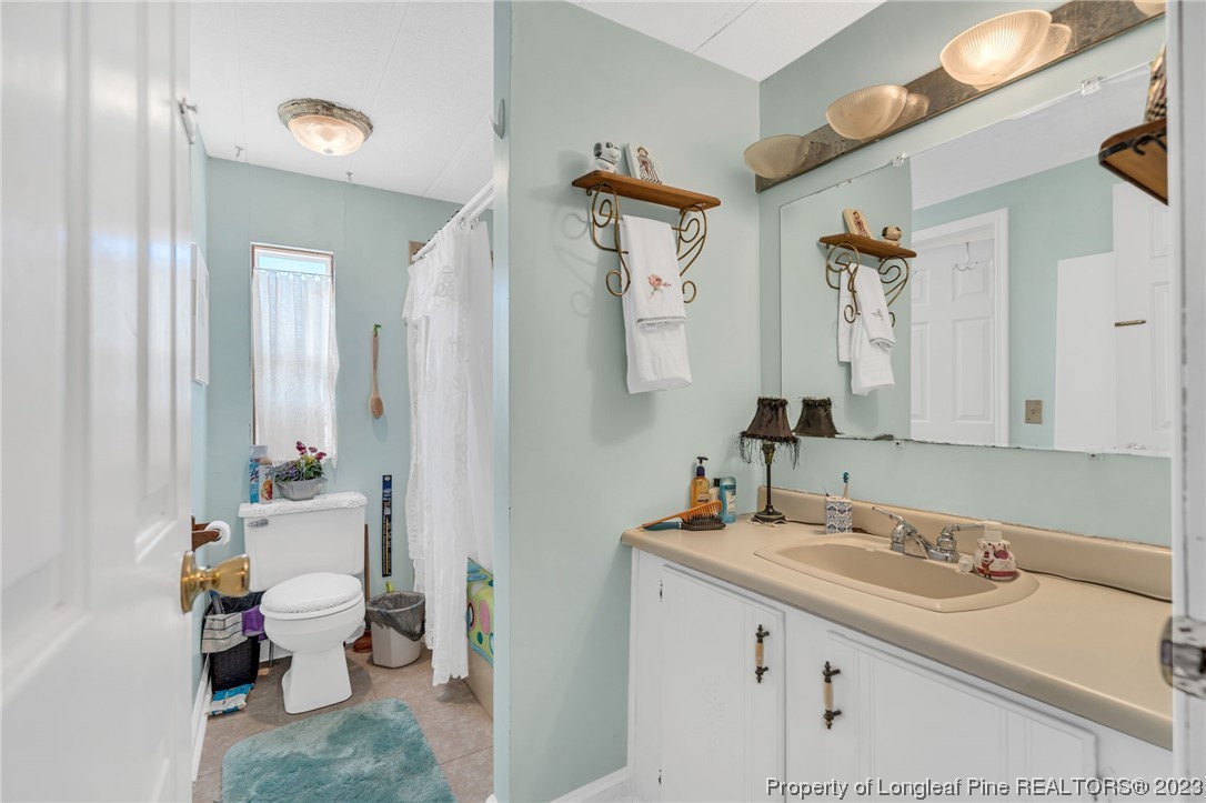 560 Moody Road Cameron, NC 28326 - Photo 17 of 29 a bathroom with a granite countertop sink mirror and toilet