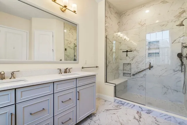 a bathroom with a double vanity sink mirror and shower