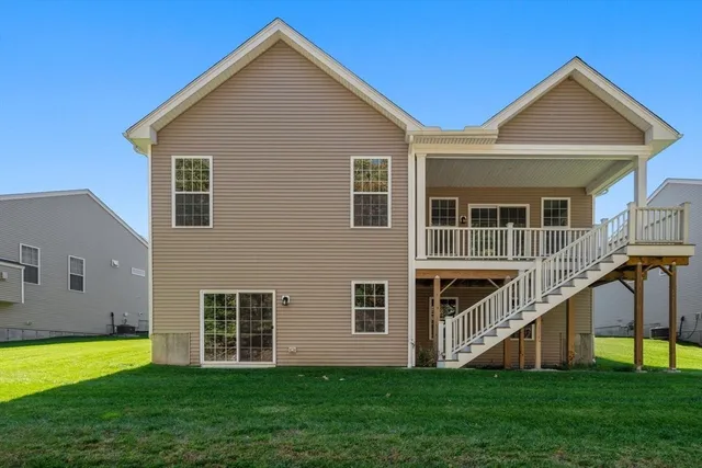a view of a house with a yard and large trees