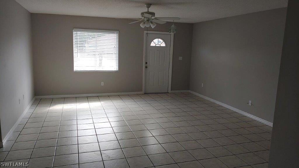 7409 Pebble Beach Road Fort Myers, FL 33967 - Photo 2 of 11 an empty room with white walls and tiles
