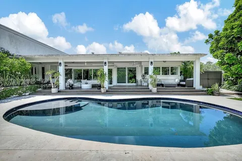 a view of house with swimming pool and outdoor seating