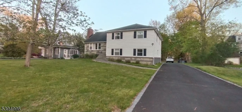 a view of a house with a yard and sitting area